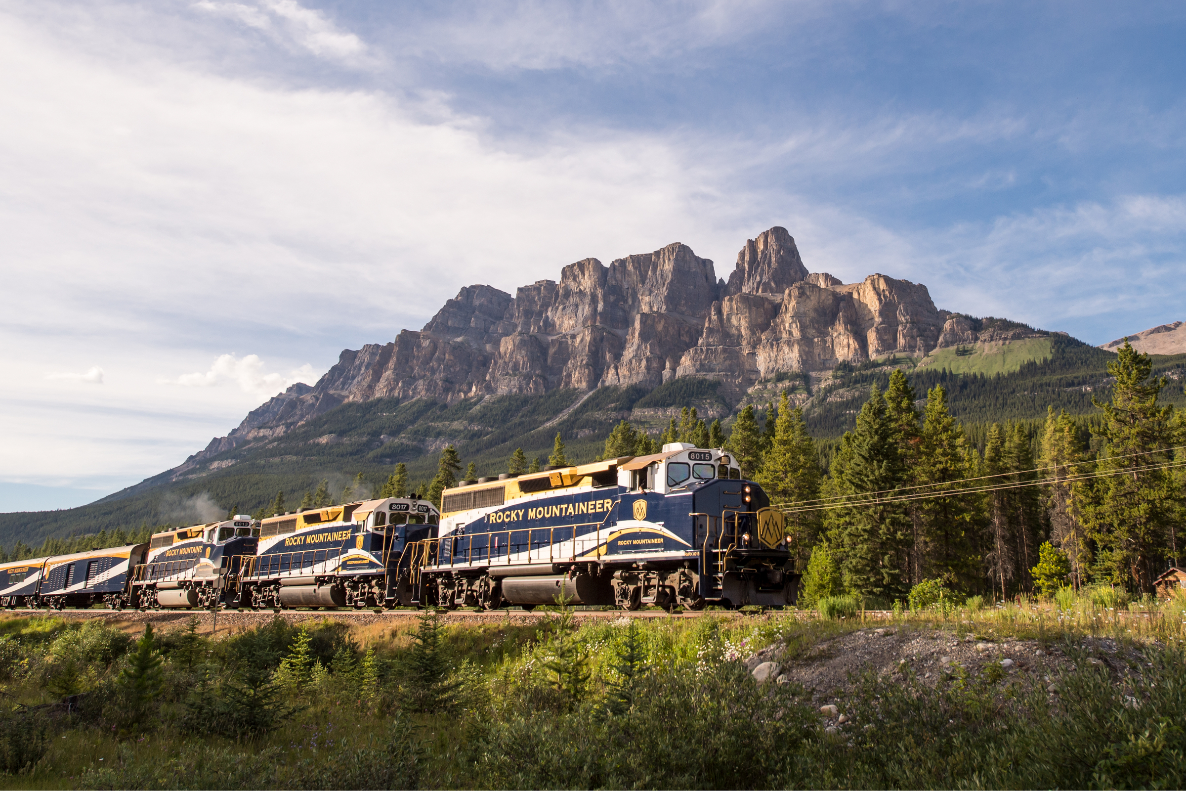 The Rocky Mountaineer train passing by Castle Mounain in the Canadian Rockies