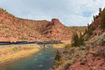 Rocky red rockes cascading over a rocky mountaineer train