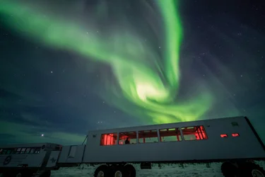 Green swirls of Northern Lights above Dan's Diner, a pop-up restaurant in Churchill during winter