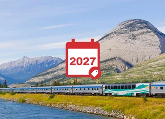 The Canadian Train rolling through the mountains with a 2027 sales icon on top.