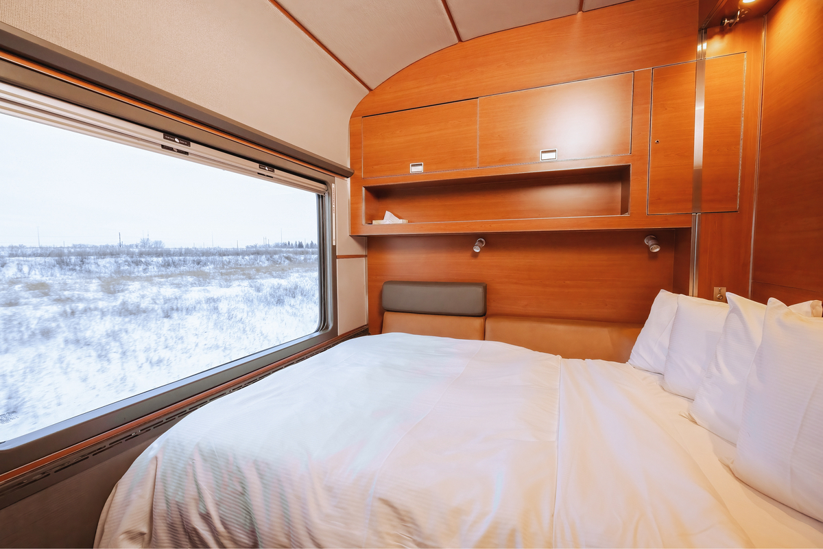 Double bed facing large window in the luxury Prestige cabin on VIA Rail Canadian train from Toronto