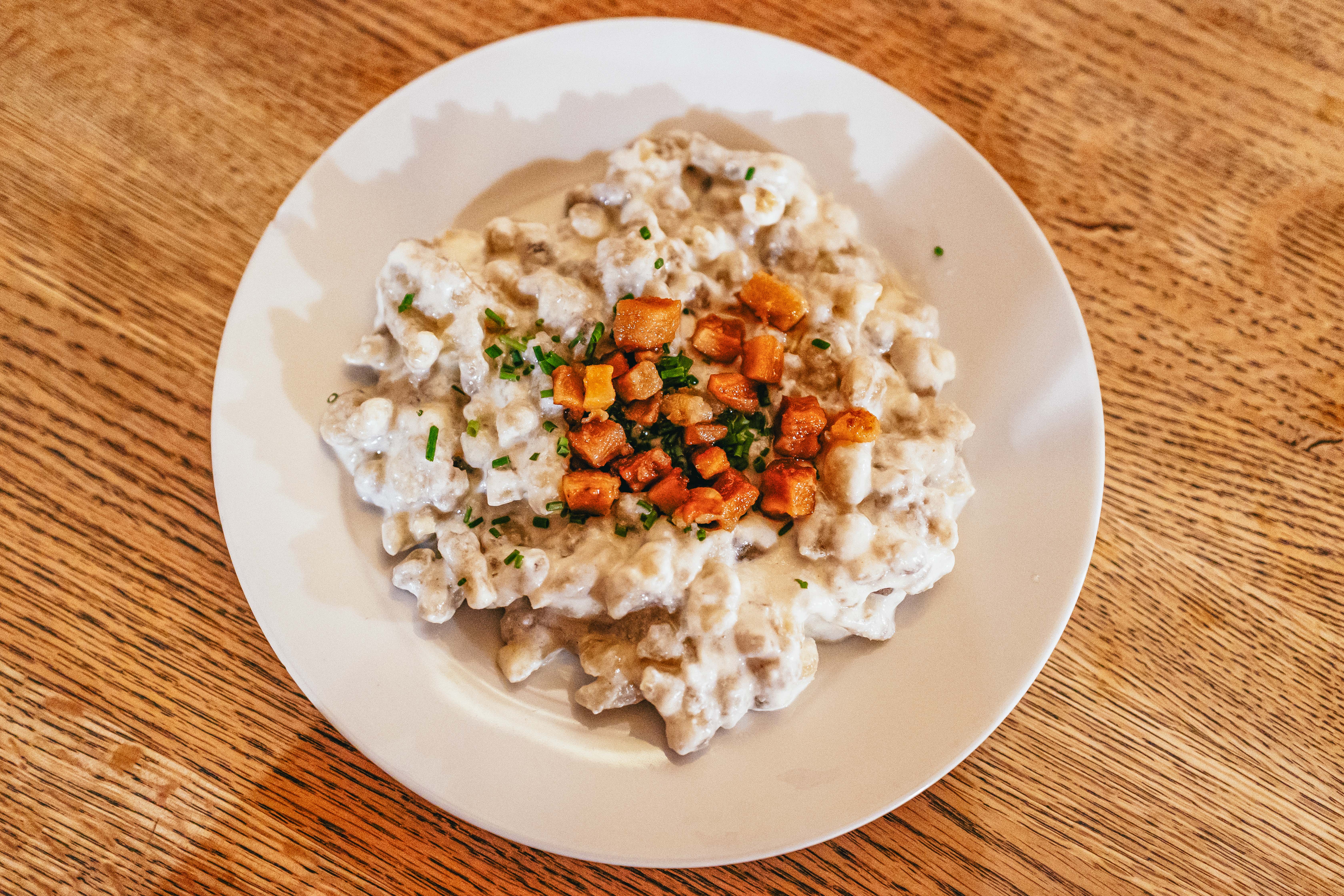 Traditional bryndzové halušky topped with sheep's cheese and crispy bacon.
