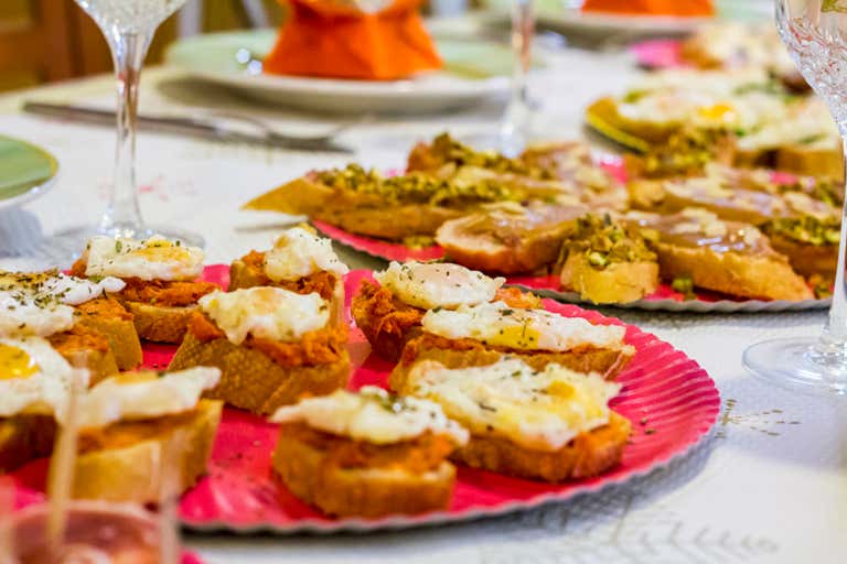 A close-up of a table with various tapas dishes on colorful plates.