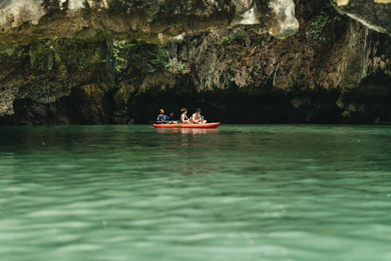 В заливе Пханг-Нга, недалеко от Пхукета, Таиланд, каякисты проплывают на каноэ через известняковые морские пещеры.