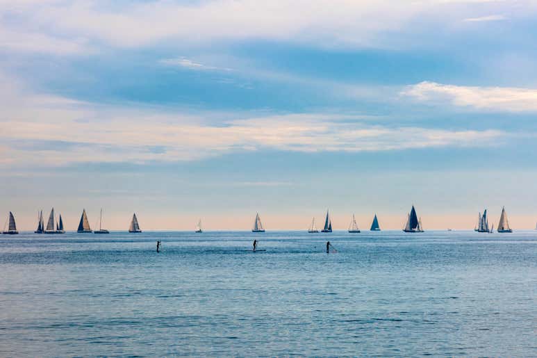 A view of sailboats on the Mediterranean Sea near Barcelona with a blue sky