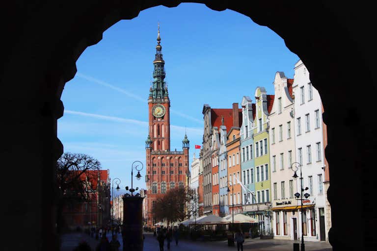 Zabytkowy Ratusz Głównego Miasta, główna atrakcja Gdańska, otoczony łukiem z kolorowymi fasadami Długiego Targu.