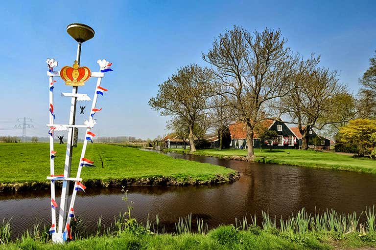 Rowerzysta jadący przez malowniczą krainę Waterland w pobliżu amsterdamskiej dzielnicy Noord.