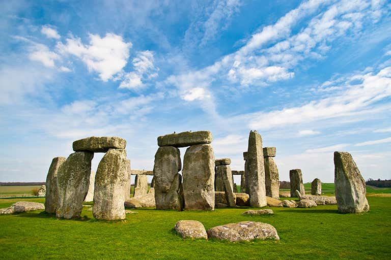 Stonehenge unter einem blauen Himmel mit vereinzelten Wolken.