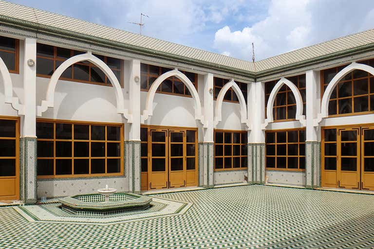 Un sereno patio con intrincados azulejos y arcos en un edificio tradicional de Agadir.