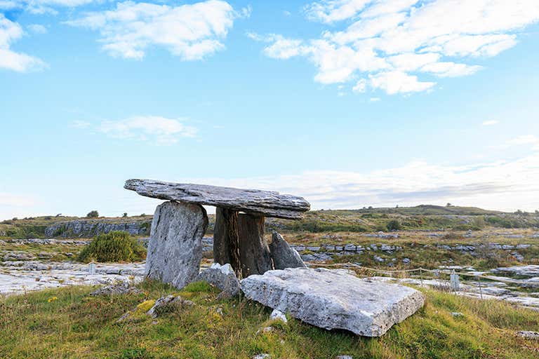 Poulnabrone Dolmen, a prehistoric portal tomb in Ireland, under a blue sky.