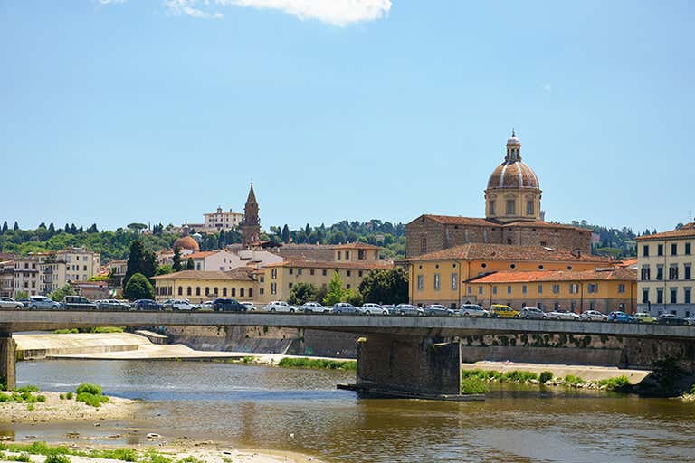 Een brug in Florence met overstekende auto's, omringd door historische gebouwen.