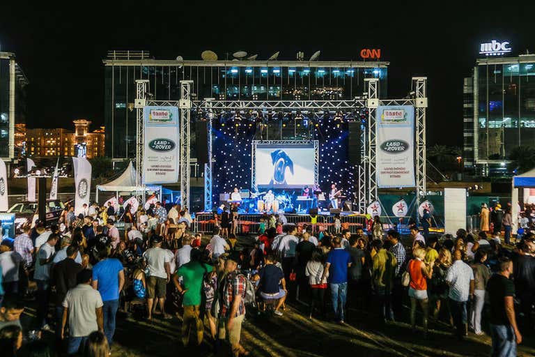 Avondpubliek geniet van eetkraampjes en entertainment tijdens het Taste of Dubai Festival in mei, met buiten dineren onder gekoelde paviljoens