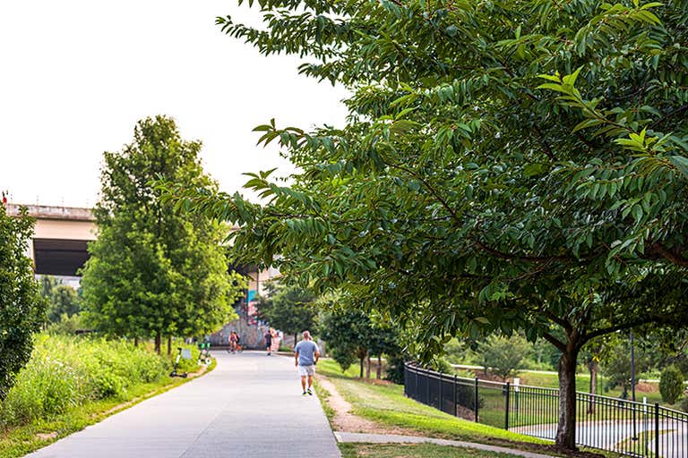 Une journée ensoleillée sur l'Atlanta BeltLine avec des arbres qui bordent le chemin.