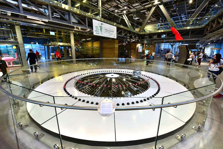 Interior do Copernicus Science Center com uma exposição com um pêndulo circular.