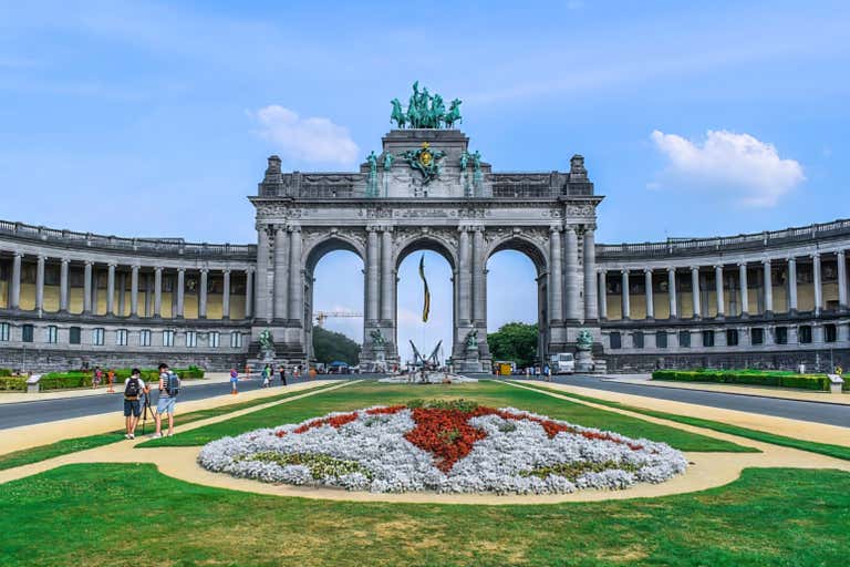 Cinquantenaire Arch in Brussels with a flower bed in the foreground.