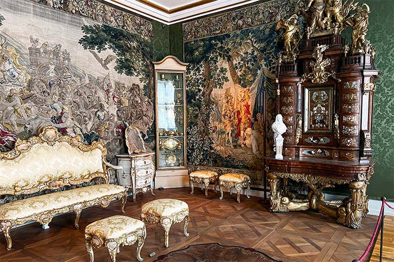 Opulent Baroque room in Rosenborg Castle featuring gilded furniture, tapestries, and ornate decorations, a royal Danish treasure