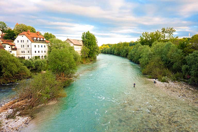 Two kayakers paddling the Sava River surrounded by rocks and greenery
