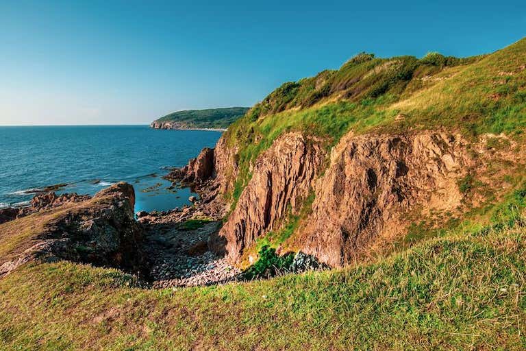 A scenic view of rocky cliffs and the ocean near Hammershus Ruins on Bornholm Island, Denmark.