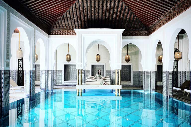 Lujosa zona de piscina cubierta con arquitectura marroquí.