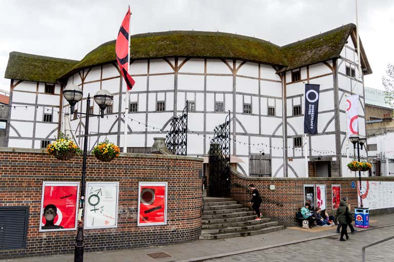 The exterior of Shakespeare's Globe Theatre in London, featuring its iconic thatched roof and timber structure.