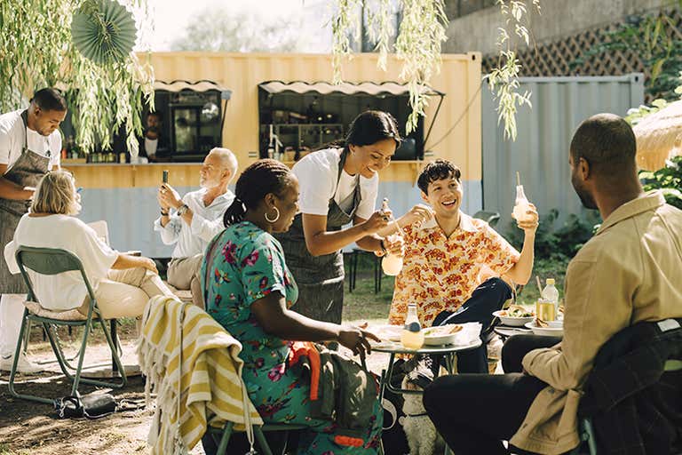Pessoas desfrutando de bebidas e comida em um café ao ar livre na Suécia.