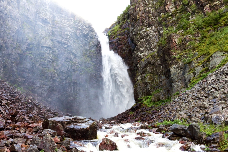 在富魯峰國家公園（Fulufjellet National Park），一道氣勢磅礡的瀑布從岩壁傾瀉而下，周圍綠意盎然。