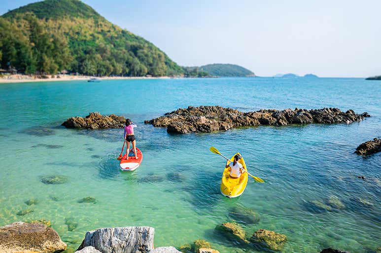 Женщина на сапборде с другом в море на острове Самуи, Таиланд, где снимали третий сезон сериала «Белый лотос».