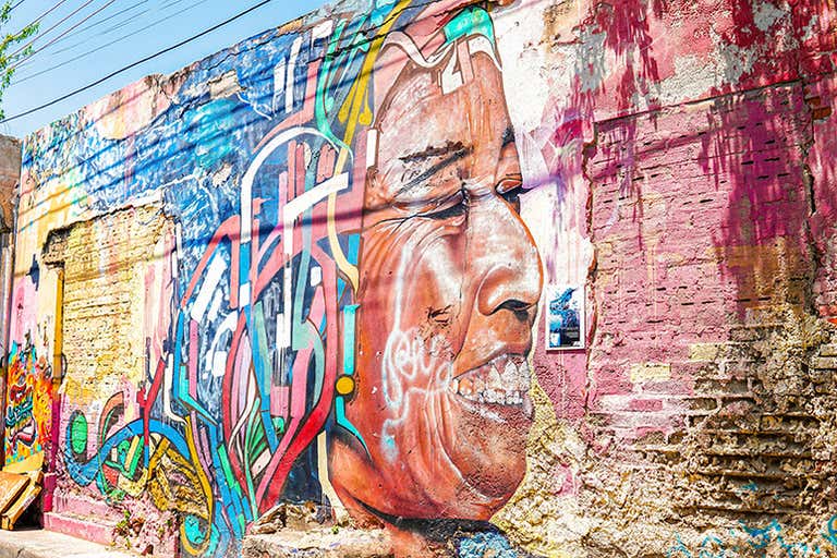 A colorful wall adorned with vibrant street art in Bogotá, featuring abstract shapes and bold patterns.