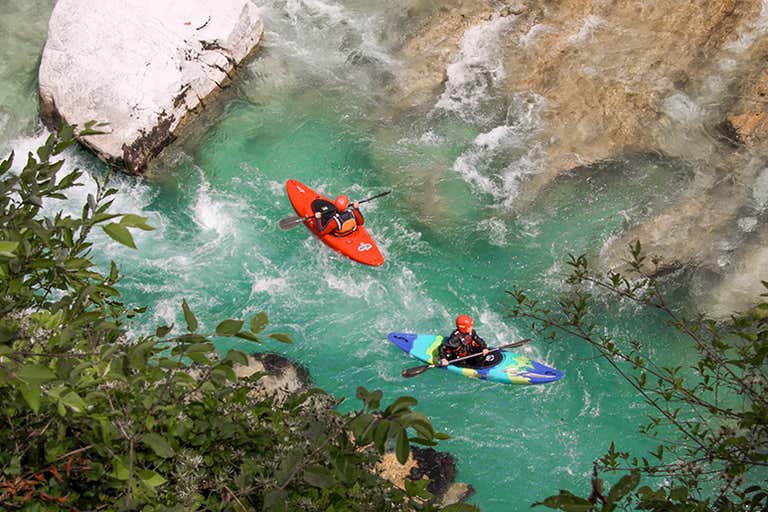 Turquoise waters of the Soča River flowing through rocky cliffs