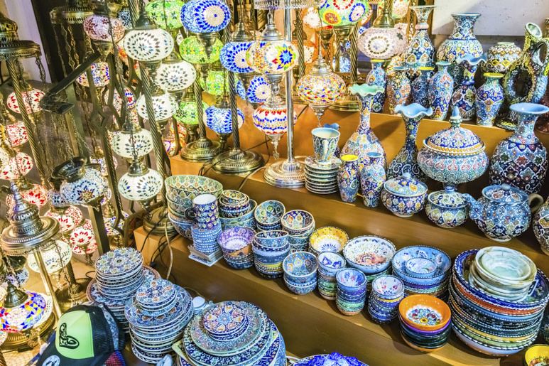 Pilas de platos y cuencos de cerámica tradicionales emiratíes y lámparas de cristal.