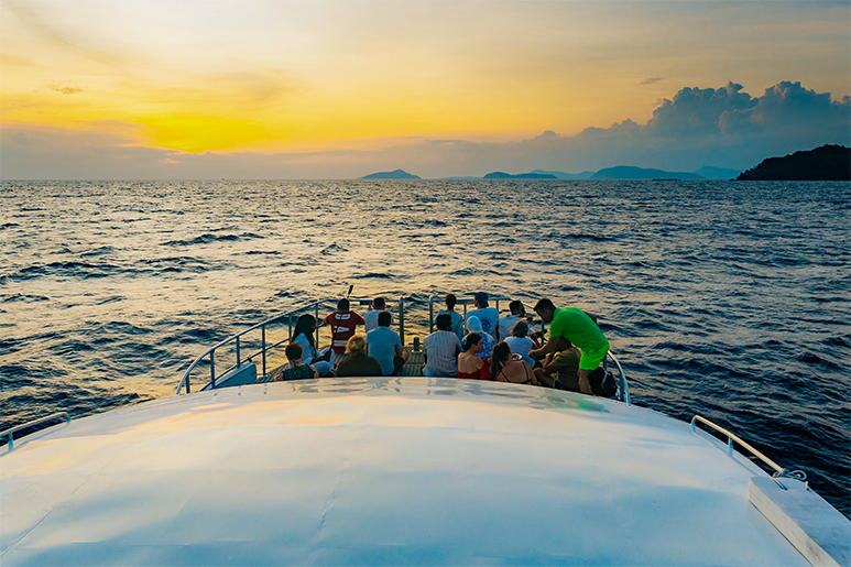 Толпа собирается на водную прогулку на закате в Пхукете.