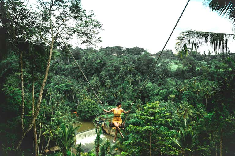 A person in a yellow dress looking down while swining on the Zen Hideaway