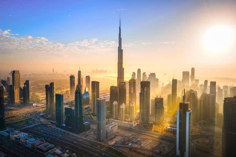 A stunning sunrise over the Dubai skyline with the Burj Khalifa prominently in view.