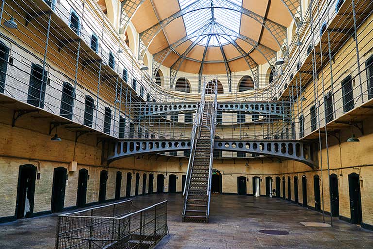 Interior view of Kilmainham Gaol with metal walkways and a central staircase.