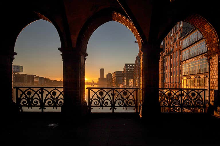 A sunrise view through the arches of Oberbaum Bridge in Berlin.