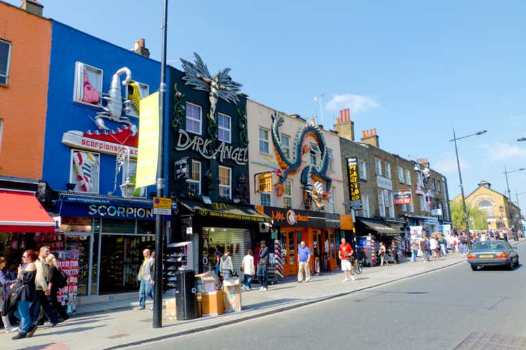 A bustling street in Camden Market, London, with colorful shopfronts and people walking.