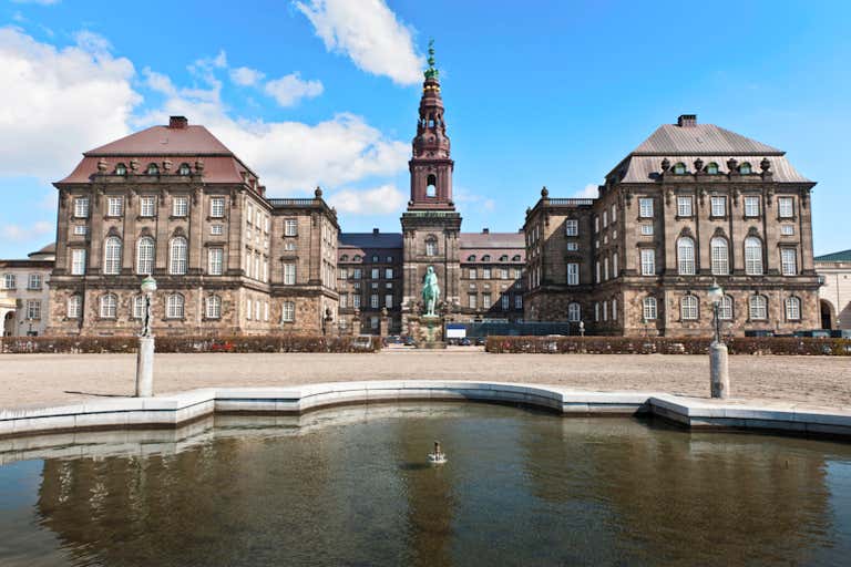 Christiansborg Palace's symmetrical baroque architecture with central tower and reflecting pool, a must-see bucket list destination in Copenhagen