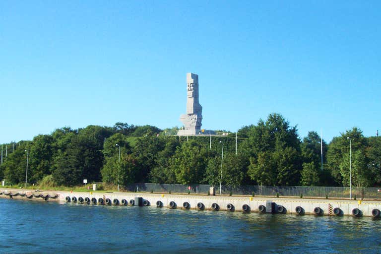 Monumentalny pomnik na Westerplatte otoczony zielenią w pobliżu Morza Bałtyckiego i Gdańska.