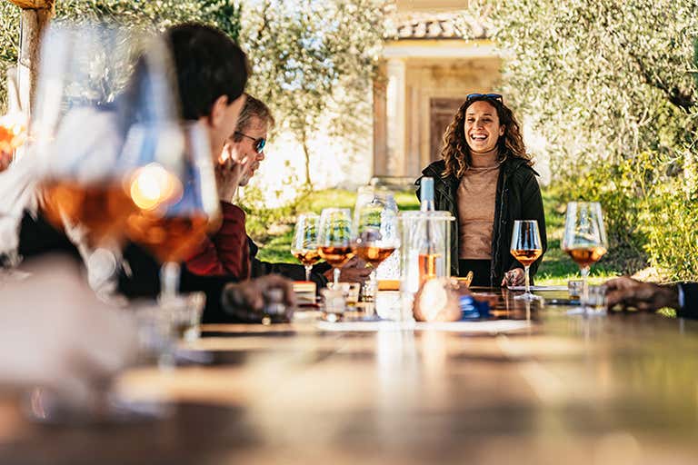 Italienische Weinverkostung draußen mit einem Glas Roséwein in einem sonnigen toskanischen Garten