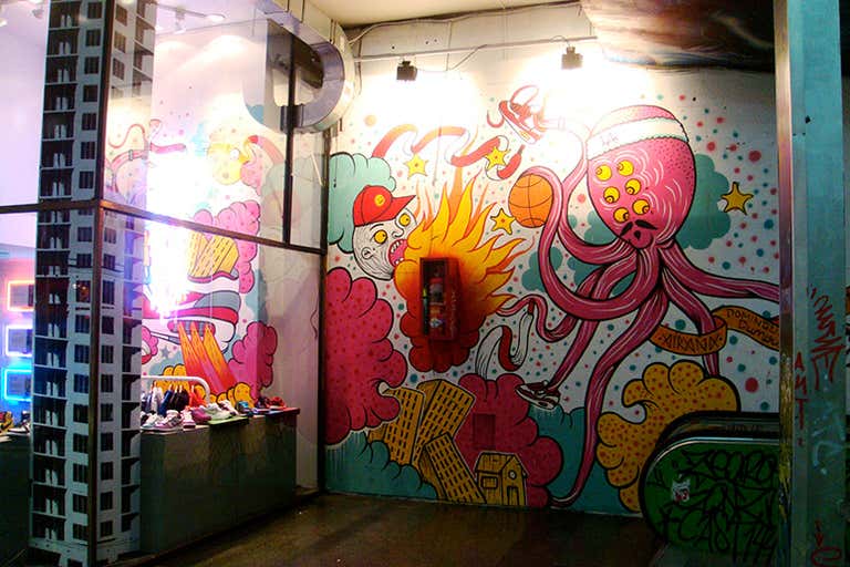 Colorful street art mural with cartoon characters and urban elements in Buenos Aires.