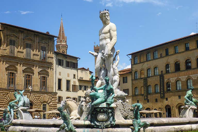 The Fountain of Neptune in Piazza della Signoria, Florence, surrounded by historic buildings.