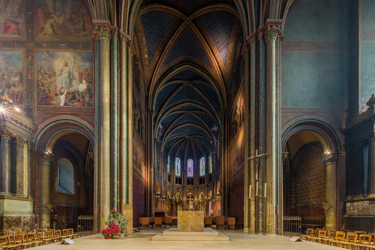 Interior of Saint-Germain-des-Prés with Gothic arches, blue ceiling with gold stars, colorful frescoes and stained glass windows