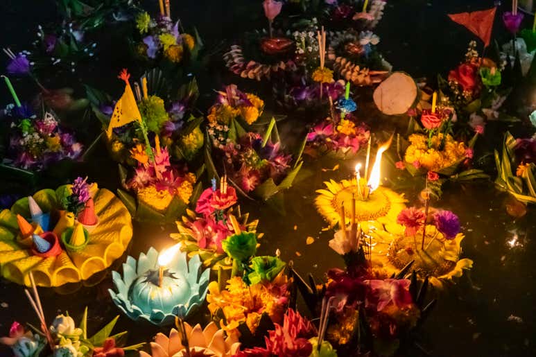 Красочные плавающие кратонги со свечами во время праздника Лойкратхонг.