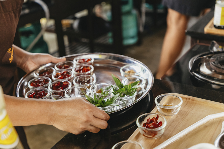 Поднос со свежими травами и специями, подготовленный для тайского кулинарного мастер‑класса.