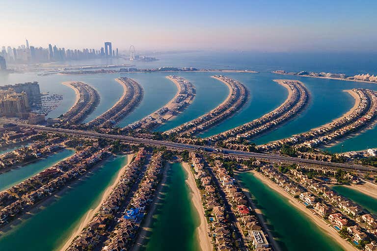 Luchtfoto van Palm Jumeirah in Dubai met de skyline van de stad op de achtergrond.