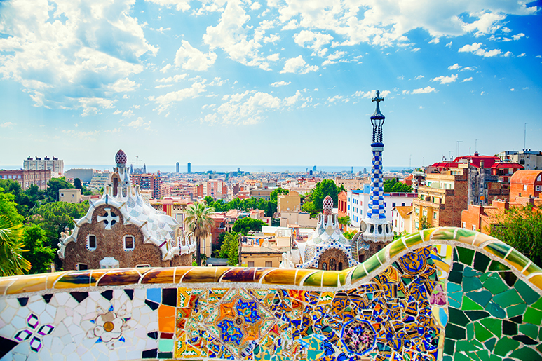 A vibrant view of Park Güell in Barcelona with colorful mosaics and cityscape