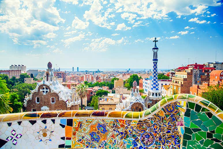 A vibrant view of Park Güell in Barcelona with colorful mosaics and cityscape