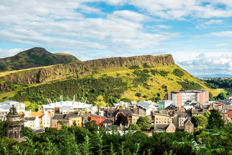 View of Arthur's Seat and surrounding buildings in Edinburgh on a sunny day