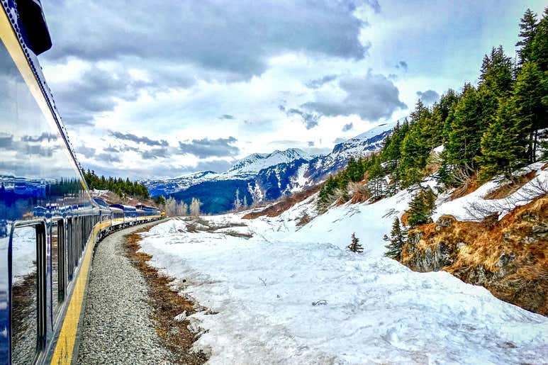 Alaska Railroad train winding through snowy mountains between Anchorage and Fairbanks.