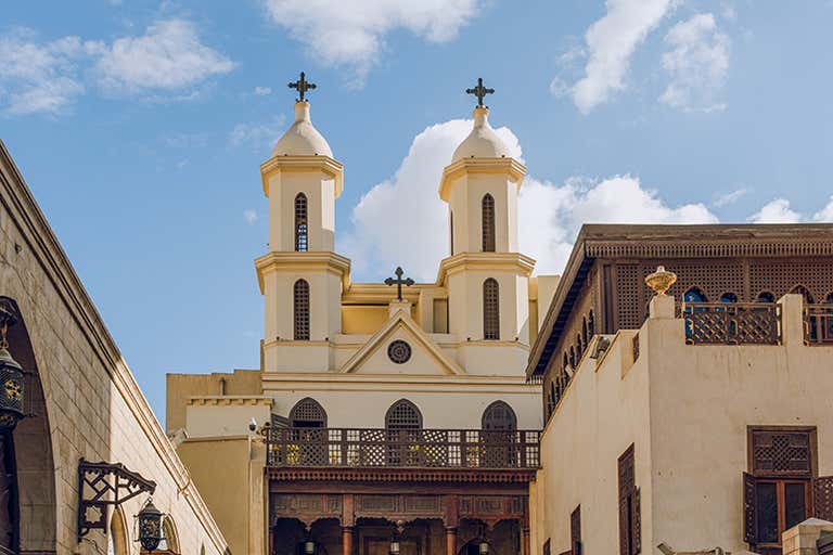 Historic Hanging Church in Cairo, Egypt, with twin bell towers and ornate architecture under a blue sky.